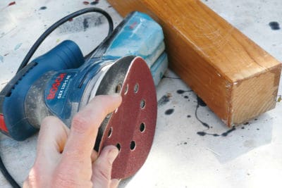 Hand holding abrasive paper